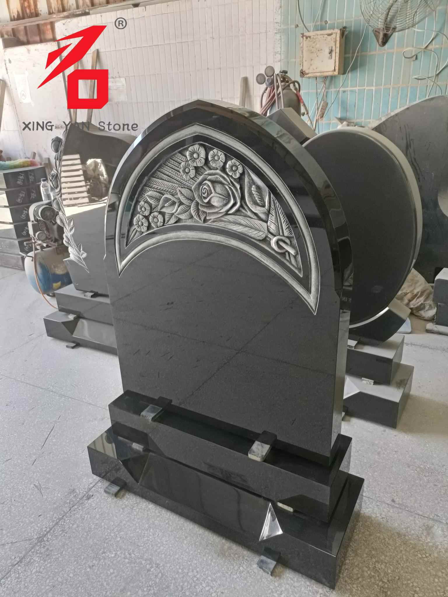 Nagrobnik z izrezljano rožico, obokan nagrobnik iz črnega granita